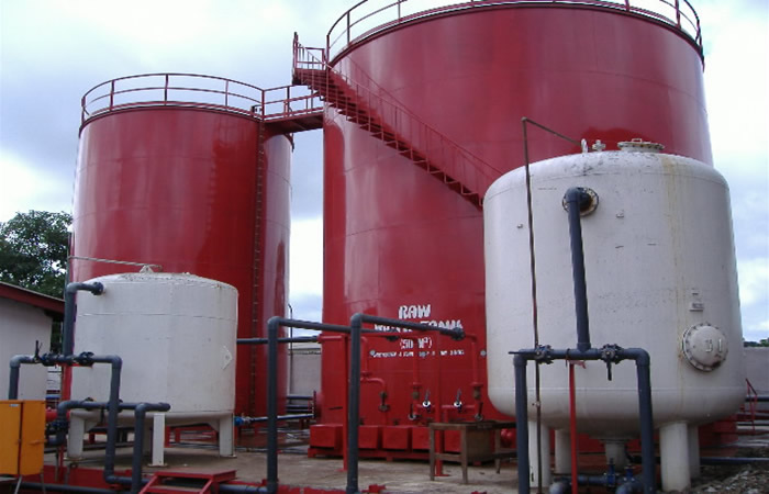 Red industrial tank farm with connected pipework